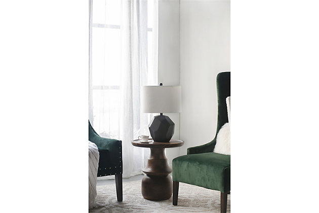 This unique table lamp features a gloss black ceramic with embossed geometric patterns accented with a round black finial. The white oval shaped hardback fabric shade provides just the right contrast that's brilliantly suited for giving rich complexity to sophisticated modern decor.Made of ceramic with hardback fabric shade | Black finish | Rotary switch | 1 type E26 bulb (not included); 60 watts max; UL Listed | Indoor use only | Imported | Assembly required