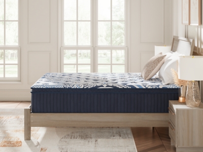 side view of queen/king bed with blue quilted mattress and matching nightstands