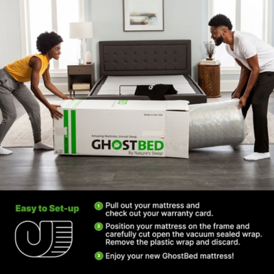 Two people unpacking and setting up GhostBed mattress from box in a bedroom