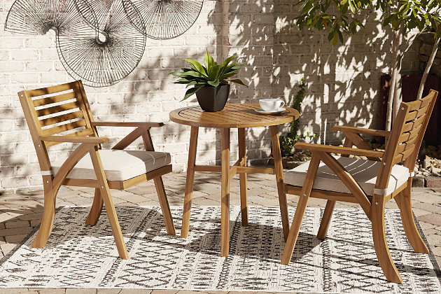 Turn an outdoor space into your own private oasis with the Vallerie 3-piece bistro set. The essence of easy-breezy outdoor living, this brilliantly styled bistro set is quality crafted of acacia wood in a natural teak tone for an exotic element. Delightfully low-maintenance seat cushions wrapped in Nuvella® fabric perfect the aesthetic.3-piece outdoor furniture set includes table and 2 chairs with cushions | Made of teak-tone acacia wood with slatted styling | Cushion covered in solution-dyed Nuvella® (polyester) high-performance fabric | All-weather foam cushion core wrapped in soft polyester | Clean fabric with mild soap and water, let air dry; for stubborn stains, use a solution of 1 cup bleach to 1 gallon water | Imported fabric and fill | Assembly required | Estimated Assembly Time: 30 Minutes