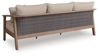 Back view of outdoor sofa with woven wicker back panel and wooden frame