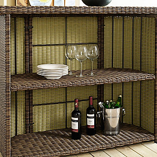 Raise the bar on al fresco living with this portable outdoor bar table. Allowing you to bring entertaining poolside, on the patio, deck or garden space with ease, the ample serving surface, tempered glass tabletop and shelf storage come together to create the ultimate outdoor bar area. Crafted from weather resistant, high-quality round wicker and a powdercoated steel frame, this is an outstanding choice for your outdoor entertaining space.Made of steel, resin wicker and tempered glass | Weathered brown faux rattan over steel powdercoat frame | 2 open shelves | Uv resistant resin wicker | Assembly required
