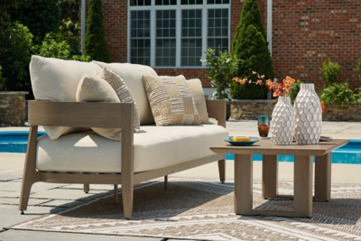 Single beige outdoor loveseat or loveseat-style sofa with wooden frame and side table