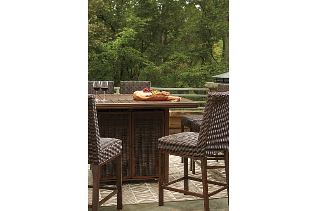 Turn your backyard space into your own piece of paradise with the Paradise Trail 7-piece outdoor fire pit table set. Though this outdoor table looks remarkably like wood, it’s made of sturdy, rust-proof aluminum that’s perfectly suited for al fresco living. Enhancing the rustically refined aesthetic: all-weather, handwoven resin wicker. The result may look high maintenance, but rest assured, this outdoor fire pit table set is anything but. With the press of a button, ignite a flickering flame that dances over a bed of glass beads. And with six high-style bar stools, it’s one highly accommodating outdoor bar table set.Includes square bar table with fire pit and 6 bar stools | Bar stools with all-weather, handwoven resin wicker over rust-proof aluminum frame; legs with wood-like finish | Fire pit table with rust-proof aluminum frame, wood-look tabletop and side panels accented with all-weather, handwoven resin wicker | 56" square fire pit table with CSA-approved 50,000 BTU stainless steel burner, glass beads, burner cover and enclosed storage area with shelves | Battery-operated ignition system with adjustable flame control; battery included | Convertible to natural gas | Table comes with protective weather cover | Door conceals gas propane tank (not included) | Assembly of fire pit table provided with in-home delivery; connection to propane tank or connector hose not provided | Estimated Assembly Time: 150 Minutes