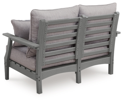 Front view of gray outdoor loveseat with two patterned throw pillows