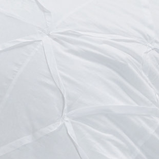 White nights. Sure to bring a boutique hotel element to your home, this quilt in brilliant white is a fresh style awakening. While the look and cottony soft feel are so luxurious, rest assured this quilt is machine washable for easy-breezy living.100% cotton face  | Hand-guided machine quilting in a diamond pattern and hand-tucked pleating  | Machine wash cold, gentle cycle, tumble dry low, do not bleach | Imported | Polyester fill | Shams not included