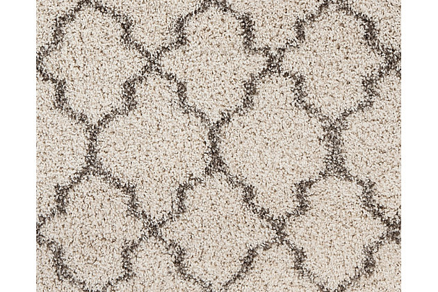 A lattice pattern in cream and charcoal weaves a touch exotic element into an everyday practical style. Subtle enough to beautifully blend. Dramatic enough to make a statement. Deep shag pile is plush beyond compare.Made of polypropylene | Machine woven | 38mm pile | Jute backing | Rug pad recommended | Spot clean only | Imported