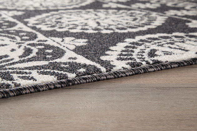 Fashioned in traditional roots, the Jicarilla accent rug fits the bill for poised and polished style. Patterned in varied ornate shapes and lined in black, cream and gray, it’s a tribal inspired look that’s guaranteed to bring a touch of exotic elegance in your home. We love how the symmetry adds to the harmonized look of the piece.Made of polypropylene | Machine woven | 8mm pile | Jute backing | Rug pad recommended | Spot clean only | Imported