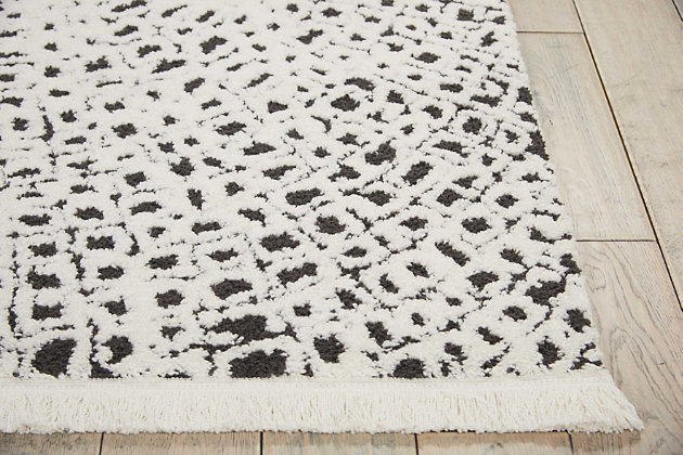 Opposites attract in the most elegant way. This fringed area rug’s striking black and white palette adds a welcome touch of sophisticated beach house style to your space. Alive with texture, it's a treat for your feet.Made of polypropylene/polyester | Machine woven | Cut pile | Latex backing; rug pad recommended | Imported | Spot clean