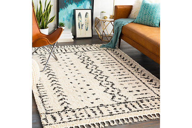 Dress up any floor with the mellow hues and energetic feel of this designer tribal rug. It welcomes visitors with warmth and comfort underfoot. Dynamic design is sure to add interest to your living space.Made of polypropylene | Machine woven | Plush pile | Rug pad recommended | Imported | Spot clean