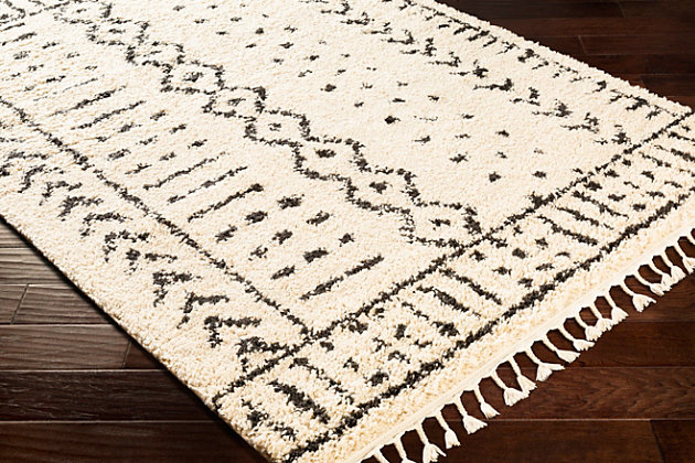 Dress up any floor with the mellow hues and energetic feel of this designer tribal rug. It welcomes visitors with warmth and comfort underfoot. Dynamic design is sure to add interest to your living space.Made of polypropylene | Machine woven | Plush pile | Rug pad recommended | Imported | Spot clean