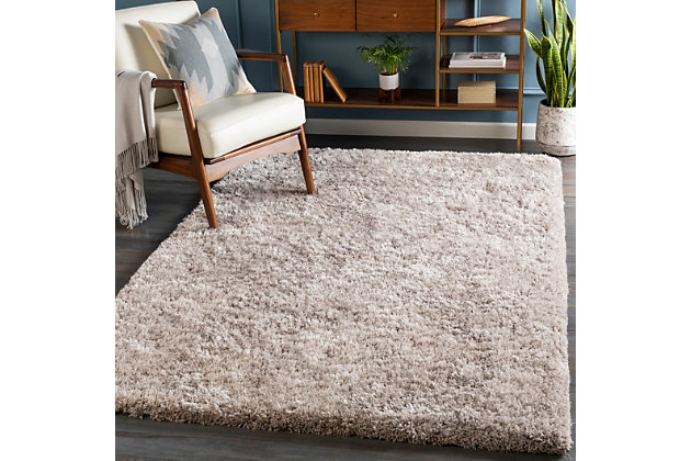 Dress up any floor with the natural hue and designer look of this rug. It welcomes visitors with warmth and comfort underfoot. Neutral color palette exudes a marvelously modern vibe which works wonders in any setting.Made of polyester | Handwoven | Shag pile | Rug pad recommended | Spot clean | Imported | Canvas backing