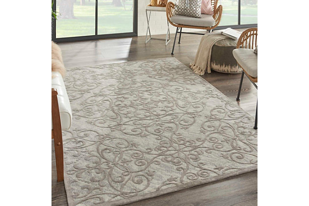 Flowing tendrils give this jacquard-woven area rug a fanciful twist. Muted palette of ivory and silvery gray is the essence of faded romance. Chenille-feel pile tantalizes with cloud-like softness.Made of polyester/cotton/rayon | Machine woven | Cotton backing; rug pad recommended | Imported | Spot clean