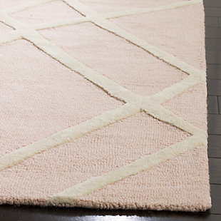Ready for some out of line style? This Safavieh kids rug gives it to you with a fun, zig-zaggy pattern. Ultra precious pink and ivory colors are understated enough to grow with your child. And with premium, hand-tufted wool, this rug will bring lasting quality to your mini-me’s room.Made of wool | Hand-tufted | Rug pad recommended | Wool fibers are prone to shedding, vacuum regularly and shedding will subside | Imported | Spot clean/dry clean recommended