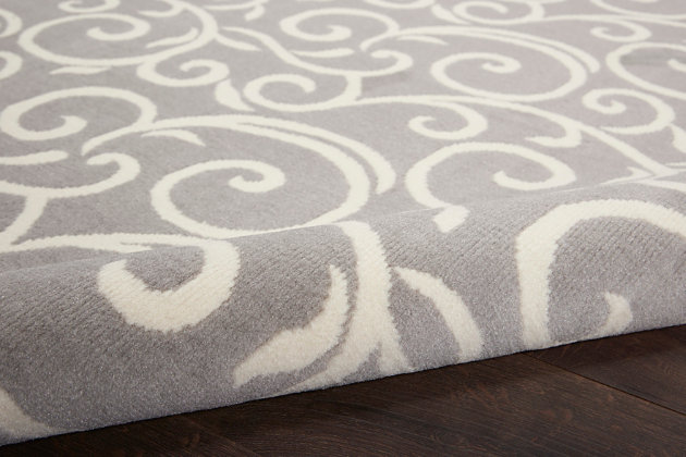Curling vines form a lush abstract garden in this grafix collection area rug. This botanical style rug features ivory patterns on a soft grey field, with voluptuous curves creating a statement of soft comfort with artistic flair.Serged edges | Easy-care fibers | Cut pile | Machine made | Power-loomed | Low shedding | Recommended for areas with moderate foot traffic | Indoor only | 100% polypropylene | Imported