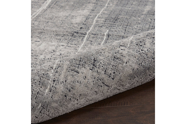 A richly-textured abstract design gives this Calvin Klein Vapor area rug unique sophistication. With its softly inviting medium pile and cool gray and ivory palette, this elevated piece is an urbane addition to the modern, eclectic home.Made of viscose and polyester | Machine made; power loomed | Backed with latex | Serged edges | Moderate shedding  | Medium pile | Vacuum regularly; no beater bar | Rug pad recommended | Imported