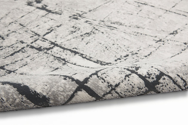 This ultra-modern area rug from the Calvin Klein Vapor Collection adds excitement to any contemporary room. Like lightning in reverse, slashes of black create visual drama across a field of artfully blended ivory and gray. It's made with a super-soft, easy-care medium pile.Made of viscose and polyester | Machine made; power loomed | Backed with latex | Serged edges | Moderate shedding  | Medium pile | Vacuum regularly; no beater bar | Rug pad recommended | Imported
