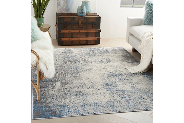 Infuse urban energy into your home with this kathy ireland® Home Grand Expressions area rug. Neutral gray, ivory and blue hues meld together in smooth abstract fashion for a refreshing color effect in contemporary settings.Made of polypropylene and polyester | Machine made; power loomed | Backed with latex | Serged edges | Low shedding | Low pile | Vacuum regularly; no beater bar | Rug pad recommended | Imported