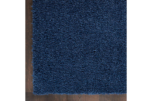 This Shangri-La shag area rug invites you to step into a pool of softness, in a rich and seductive navy blue. Densely structured to create textured shadow and light, this rug exudes casual elegance.Made of polypropylene | Machine made; power loomed | Backed with jute | Serged edges | Shag pile | Low shedding | Rug pad recommended | Vacuum regularly; no beater bar | Imported