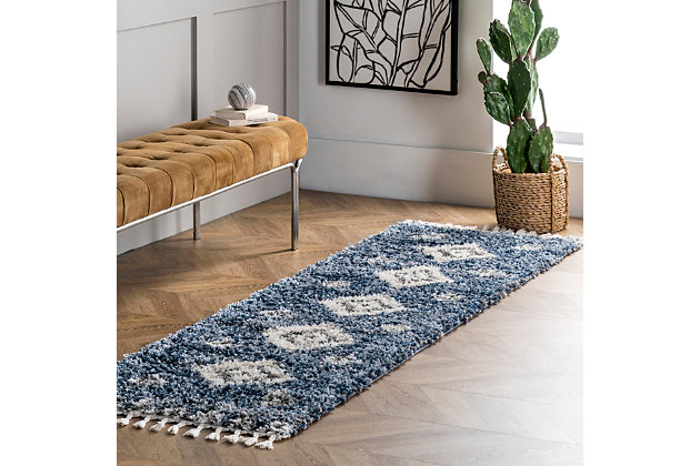 Step into comfort with the luxuriously soft and fluffy texture of this rug that simply has it all. You are sure to enjoy its contemporary style, plush pile, and braided tassel edges. The perfect addition to any space in your home that needs a touch of style and comfort, you may just find yourself relaxing directly on this rug. Machine-made of polypropylene to ensure durability and ease of care.100% polypropylene | High pile (1.5") | Step into comfort with the soft and fluffy texture of a shag rug | The perfect cozy rug for your bedroom, living room, or hallway | Fresh and of the moment, this contemporary rug adds the right amount of chic to your space | Easy to care for (we recommend vacuuming regularly to reduce potential shedding; spot clean any stains with carpet cleaner) | Includes 3" braided tassels on both ends | Imported