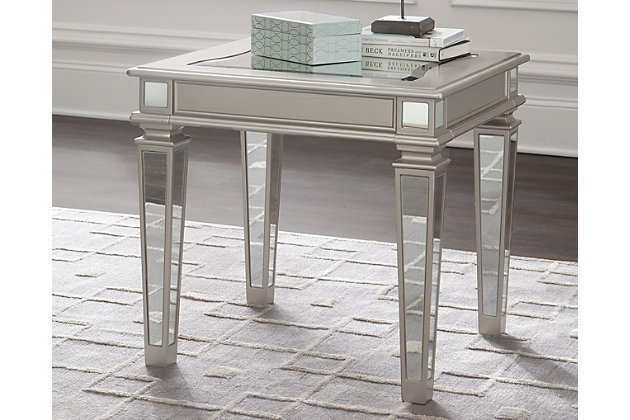 With glitz and glam worthy of a queen, the Tessani end table is ravishing. Tabletop is adorned with a slightly curved mirrored beveled glass inset. Apron panels marry in alluring mirrored legs. With its silver sheen finish, this table will make you feel like royalty.Made of wood and engineered wood | Beveled mirrored glass inset | Assembly required | Estimated Assembly Time: 15 Minutes