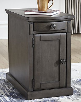 So much form and function in a beautifully compact piece of furniture. The richly styled Laflorn chairside end table puts it all within reach, including a flip-up top panel revealing a power port—perfect for keeping your phone or laptop charged. Hidden twin cup holders and interior shelved storage are also a welcome surprise. With an attractive gray-tone finish, this piece easily complements other furnishings.Hand-finished | Made of veneers, wood and engineered wood | Aged bronze-tone hardware | 1 cabinet with 1 adjustable shelf | Pull-out tray with 2 recessed cup holders and remote control slot | Flip-top compartment with 3 electrical outlets, 2 USB slots | Power cord included; UL Listed | Assembly required | Estimated Assembly Time: 15 Minutes
