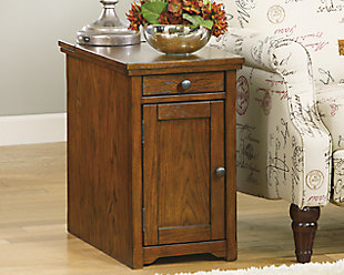 So much form and function in a beautifully compact piece of furniture. Richly crafted with a warm and rustic style, the Laflorn chairside end table puts it all within reach, including a flip-up top panel revealing a power port—perfect for keeping your phone or laptop charged. Hidden twin cup holders and interior shelved storage are also a welcome surprise.Hand-finished | Made of veneers, wood and engineered wood | Assembly required | 1 cabinet with 1 adjustable shelf | Pull-out tray with 2 recessed cup holders and remote control slot | Flip-top compartment with 3 electrical outlets, 2 USB slots | Power Cord, UL listed | Pewter-tone hardware | Excluded from promotional discounts and coupons