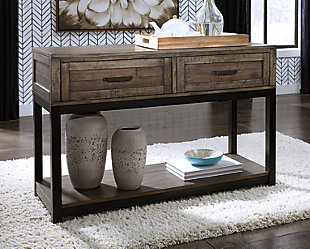 Combining a two-tone finish with a gently distressed texture produces one very distinctive sofa table. Whether your style is modern farmhouse or urban industrial, the Johurst sofa table is the perfect accent for your rustic retreat.Made of wood, veneers and engineered wood | Rustic two-tone finish; distressed brown and black metallic | 2 smooth-gliding drawers | Aged bronze-tone pulls | Lower fixed shelf | Estimated Assembly Time: 15 Minutes