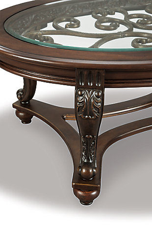 The Norcastle oval coffee table deserves a toast for incorporating so many elements so seamlessly. Swirls of metal accents add a  lovely dimension under a beveled glass inset tabletop. Their fanciful pattern is echoed in the carvings and curves of the richly stained legs and stretchers.Hand-finished | Beveled glass top with scrollwork underlay | Assembly required | Made of veneers, wood and engineered wood with cast resin accents and glass top | Estimated Assembly Time: 30 Minutes