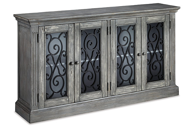 Rustic refinement is brilliantly on display in the Mirimyn cabinet. Whether gracing the dining room, living room, office or entry, it’s an eclectic piece loaded with versatility and charm. Ornately scrolled grillwork on the glass-front doors adds a touch of romance. Adjustable shelving enhances the form and function.Made of veneers, wood and engineered wood | 2 adjustable shelves | 4 cabinet doors with clear glass inlays and metallic cast resin grills | Assembly required | Excluded from promotional discounts and coupons | Estimated Assembly Time: 30 Minutes