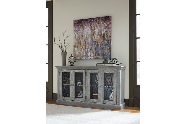 Rustic refinement is brilliantly on display in the Mirimyn cabinet. Whether gracing the dining room, living room, office or entry, it’s an eclectic piece loaded with versatility and charm. Ornately scrolled grillwork on the glass-front doors adds a touch of romance. Adjustable shelving enhances the form and function.Made of veneers, wood and engineered wood | 2 adjustable shelves | 4 cabinet doors with clear glass inlays and metallic cast resin grills | Assembly required | Excluded from promotional discounts and coupons | Estimated Assembly Time: 30 Minutes
