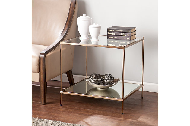 By infusing goldtone metal with both clear and mirrored glass, this decidedly modern end table takes minimalism to the max. Underlying shelf gives its fabulous form that much more function.Plated iron frame in goldtone finish | Clear tempered glass tabletop | Bottom shelf with mirrored glass top | Assembly required | Assembly time frame is 15 to 30 min.
