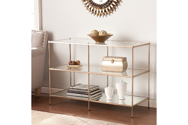 By infusing goldtone metal with both clear and mirrored glass, this decidedly modern console table takes minimalism to the max. Tri-level design gives its fabulous form that much more function.Plated iron frame in goldtone finish | Clear tempered glass tabletop and center shelf | Bottom shelf with mirrored glass top | Assembly required | Assembly time frame is 15 to 30 min.