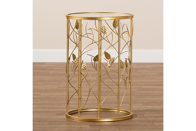 Accent your space with the luxurious and eye catching design of the Anaya end table. Made in China, the Anaya is comprised of a brushed gold finished metal frame fitted with a circular glass tabletop. Inspired by nature, the base showcases a unique leaf and vine design that allows light to easily flow throughout the room. Fully assembled, its slim silhouette makes it well suited for placement next to a sofa or chair. A stunning design that helps brighten any space, the Anaya end table is a fantastic addition to the modern home.Modern and contemporary glam end table | Constructed from metal and tempered glass | Brushed gold finish | Glass tabletop