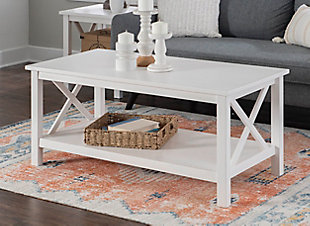 This sturdy coffee table makes itself at home in living rooms of all shapes and styles. A welcoming and versatile centerpiece, you can use its wide, smooth surface to showcase your favorite display items or serve trays of food when guests come over. The large lower shelf offers extra storage, and the crisscross sides add interest to this modern farmhouse piece. It is crafted from solid pine with an antique white finish that allows the beauty of the wood grain to show through. It also works perfectly as a media stand holding a TV, plus ample space below.Welcoming centerpiece with large, versatile surface | Modern farmhouse design that compliments any style | Crafted from solid pine with subtle wood grain under the antique white finish | Large lower shelf provides extra storage | Classy X design on sides | Can also work perfectly as a media stand | Part of a collection | Easy to assemble | Weight Limit: 30 lbs on Top, 15 lbs on Shelf | Top Dimension: 44" x 22", Shelf Dimension: 39" x 19.12", Distance from floor to bottom of item: 3.87"