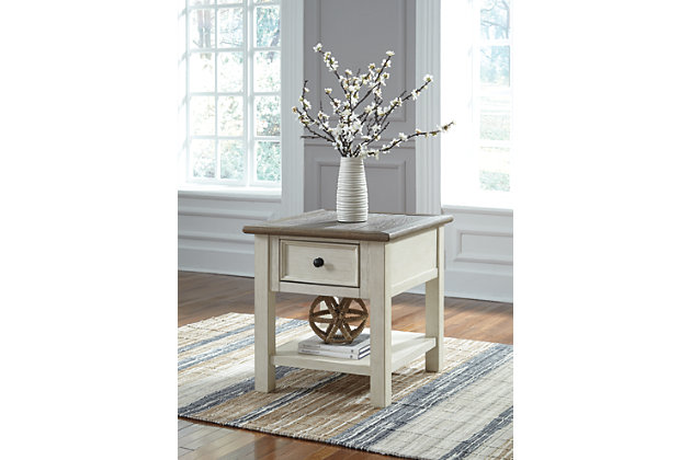Whether your style is farmhouse fresh, shabby chic or country cottage, you’ll find the Bolanburg end table dressed to impress. Its two-tone, gently distressed finish pairs weathered oak with antique white for that much more quaint character. Charming elements include a plank-and-frame style top, black faceted hardware and a smooth-gliding drawer for remote controls and more.Made of veneers, wood and engineered wood | Two-tone finish (weathered oak over antique white) | Plank-style top | Smooth-gliding drawer | Black faceted hardware | Estimated Assembly Time: 15 Minutes