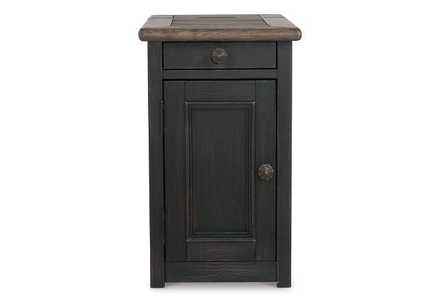 Shabby chic with a hint of down home country. The Tyler Creek chairside end table with textured black finish is all the talk of today’s design world. Wood grain shows through the weathered gray-brown top in all of its earthy pleasure. Pull-out tray with lovely traditional hardware has two cup holders. Fuel up your devices with the convenient charging station.Made of solid and engineered wood and veneers | Dark bronze-tone hardware | 1 door; 1 fixed shelf | Pull-out tray with 2 cup holders | AC power supply with 2 USB charging ports | Assembly required