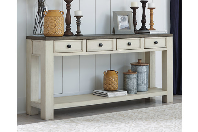 The beautiful cottage style of the Bolanburg sofa table gets a contemporary update. Sporting a plank-effect top and a textured two-tone finish, this sofa table blends timeworn character with modern functionality. Four convenient drawers and a spacious lower shelf lend dimension to the design.Made of veneer, wood and engineered wood | Two-tone textural finish: antique white base; weathered oak finished top | 4 smooth-gliding drawers | Fixed shelf | Assembly required | Estimated Assembly Time: 30 Minutes