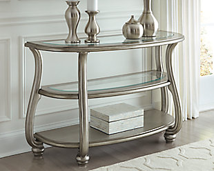 The Coralayne sofa table allures with the glitz and glam befitting silver screen queens. Exquisite frame with swan neck legs and a sublime metallic finish channel that Hollywood Regency flair. Clear glass inlays on the tabletop and middle shelf elevate Coralayne to interior fashion's A list.Made of engineered wood and resin | Metallic sheen finish | Top 2 tiers with beveled glass inlays | Swan neck legs | Assembly required | Estimated Assembly Time: 45 Minutes