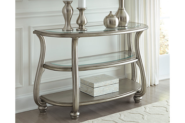 The Coralayne sofa table allures with the glitz and glam befitting silver screen queens. Exquisite frame with swan neck legs and a sublime metallic finish channel that Hollywood Regency flair. Clear glass inlays on the tabletop and middle shelf elevate Coralayne to interior fashion's A list.Made of engineered wood and resin | Metallic sheen finish | Top 2 tiers with beveled glass inlays | Swan neck legs | Assembly required | Estimated Assembly Time: 45 Minutes