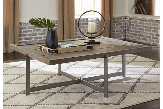 Take a stance for minimalism done right with the Krystanza coffee table. Crafted with earthy elegant pine veneer and wood, the tray top is beautified with a weathered gray finish. Linear metal legs in aged pewter-tone make quite the striking complement for your open-concept space.Top made of pine veneer, wood and engineered wood in a weathered gray finish | Pewter-tone metal legs | Assembly required | Estimated Assembly Time: 30 Minutes