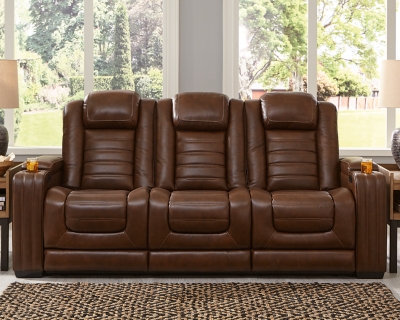 With its fashion-forward sense of style, the Backtrack power reclining sofa has you covered with high-tech advancements and down-home comfort. For starters, the seating area and armrests are upholstered in real leather for true indulgence where it matters most. Love being pampered? With the touch of a button, experience the pure bliss of an air massage system (with three settings), or chill out with the heated seat element. Distinctive elements of this power recliner include contemporary waterfall tufting that beautifully goes with the flow and a zero-gravity mechanism further raising the ottoman for better blood flow. Dual-sided recliner | One-touch power control with adjustable positions, Easy View™ adjustable headrest and zero-draw USB plug-in | Zero-draw technology only consumes power when the USB receptacle is in use | Air massage system includes 3 settings: steady, pulse and wave (with automatic 20-minute shutoff feature) | Heat in the seat element (with automatic 30-minute shutoff feature) | Corner-blocked frame with metal reinforced seat | Attached back and seat cushions | High-resiliency foam cushions wrapped in thick poly fiber | Hidden armrest storage compartments | Zero-gravity mechanism (raises the ottoman to 23" off the floor for improved blood flow) | Extended ottoman for enhanced comfort | Leather interior seating; vinyl/polyester exterior upholstery | Middle seat with flip-down table and 2 cup holders | Estimated Assembly Time: 15 Minutes