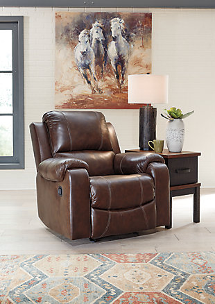 Once you recline in the Rackingburg rocker recliner with the pull of a tab, you will not want to get up. It's that comfortable with a bustle back and padded ottoman. Its look is amazing with dramatic cut and sew lines, jumbo stitching and affordable mahogany leather match upholstery, which features top-grain leather in the seating areas with skillfully matched vinyl everywhere else—what a way to relax.Bustle back | Attached cushions | Corner-blocked frame with metal reinforced seat | Pull-tab reclining motion | Leather interior upholstery/polyester and vinyl exterior upholstery | High-resiliency foam cushions wrapped in thick poly fiber