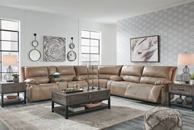 Life is so much better when you can enjoy the pleasure of real leather—at a price to put you at ease. That’s exactly what you get with the Ricmen reclining sectional with power. Thanks to real leather throughout the seating area, you've got a reclining sectional that feels like a million bucks but won’t break the bank. Tailored to those with an eye for contemporary design, this power reclining sectional is dressed to impress with an upscale matte finish, clean-lined divided back tufting, distinctive jumbo stitching and chic pillow top armrests. Perhaps best of all: Easy View™ power adjustable headrests let you recline back and still have a primo view of the TV.Includes 3 pieces: power reclining loveseat, 2 seat power reclining sofa and wedge | Dual-sided recliner | One-touch power control with adjustable positions | Corner-blocked frame with metal reinforced seat | Attached cushions | High-resiliency foam cushions wrapped in thick poly fiber | USB charging port in power control | Easy View™ power adjustable headrests | Loveseat console with storage and 2 cup holders | Leather interior upholstery; vinyl/polyester exterior upholstery | Power cord included; UL Listed | Estimated Assembly Time: 10 Minutes