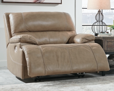 Life is so much better when you can enjoy the pleasure of real leather—at a price to put you at ease. That’s exactly what you get with the Ricmen wide seat power recliner. Thanks to real leather throughout the seating area, you've got a recliner that feels like a million bucks but won’t break the bank. Tailored to suit those with an eye for contemporary design, this power recliner is dressed to impress with an upscale matte finish, clean-lined divided back tufting, distinctive jumbo stitching and chic pillow top armrests. Perhaps best of all: an Easy View™ power adjustable headrest lets you recline back and still have a primo view of the TV.One-touch power control with adjustable positions | Corner-blocked frame with metal reinforced seat | Attached cushions | High-resiliency foam cushions wrapped in thick poly fiber | USB charging port in power control | Easy View™ power adjustable headrest | Extended ottoman for enhanced comfort | Leather interior upholstery; vinyl/polyester exterior upholstery | Power cord included; UL Listed