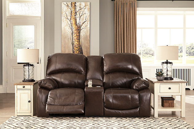 Fashion-forward style. Sumptuous leather feel and appeal. Total comfort at your fingertips. It’s all yours for the taking with the Hallstrung power reclining loveseat with console. Wrapped in a rich chocolate brown upholstery, this decidedly contemporary power loveseat tantalizes the senses in so many ways. Rest assured, the seating area is covered in 100% leather for your pleasure, while a skillfully matched faux leather on the exterior makes luxury affordable. Upping the comfort with 44" high back styling, this power loveseat truly caters from head to toe. An Easy View™ power adjustable headrest allows you to lean back while propping up your head—perfect for chilling out in front of the TV—while an extended ottoman lets you stretch out all the more. And with a USB port in each power control panel, you hardly have to move a muscle to stay powered up.Dual-sided recliner | One-touch power controls with adjustable positions | Corner-blocked frames with metal reinforced seats | Easy View™ power adjustable headrests | 44" high back design | Attached backs and seat cushions | High-resiliency foam cushions wrapped in thick poly fiber | Leather interior upholstery; polyester/vinyl upholstery | Lift-top storage console and 2 stainless steel cup holders | Extended ottomans for enhanced comfort | Includes USB charging port in each power control | Power cord included; UL Listed | Estimated Assembly Time: 15 Minutes
