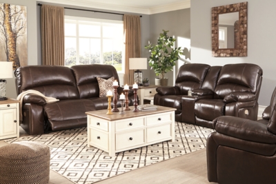 Fashion-forward style. Sumptuous leather feel and appeal. Total comfort at your fingertips. It’s all yours for the taking with the Hallstrung power recliner with adjustable headrest. Wrapped in a lavish chocolate-colored upholstery, this decidedly contemporary power recliner tantalizes the senses in so many ways. Rest assured, the wide seating area is covered in 100% leather for your pleasure, while a skillfully matched faux leather on the exterior makes luxury affordable. Upping the comfort with 44" high back styling, this power recliner truly caters from head to toe. An Easy View™ power adjustable headrest allows you to lean back while propping up your head—perfect for chilling out in front of the TV—while an extended ottoman lets you stretch out all the more. And with a USB port in the power control panel, you hardly have to move a muscle to stay powered up.High-resiliency foam cushions wrapped in thick poly fiber | Corner-blocked frame with metal reinforced seat | One-touch power control with adjustable positions | 44" high back design | Attached back and seat cushions | Easy View™ power adjustable headrest | Extended ottoman for enhanced comfort | Leather interior upholstery; polyester/vinyl exterior upholstery | Includes USB charging port in each power control | Power cord included; UL Listed | Estimated Assembly Time: 15 Minutes