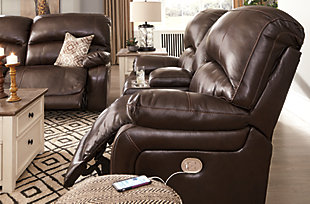 Stay happy at home feeling as if you're floating on a cloud with the Hallstrung 2-seat reclining power sofa with Easy View™ power adjustable headrests. Comfort is immediate when you're in control of your relaxation. Simply adjust the seat's position and headrest with the easy one-touch power control buttons. Plus, with the convenient USB charging ports, cell phones or laptops can be charged without having to get up. The feel of heavy weight luxurious leather surrounds you via the cushioned seat, interior bustled back cushioning and pillow top armrest, while faux leather on the back and sides is easy on the eyes and the wallet. The chocolate-colored upholstery provides a modern look in a high back design that's traditional—what a great way to unwind and watch TV.Dual-sided recliner; middle seat stays stationary | One-touch power control recliners with adjustable positions | Includes USB charging port in each power control | Corner-blocked frames with metal reinforced seats | Attached backs and seat cushions | High-resiliency foam cushions wrapped in thick poly fiber | Easy View™ power adjustable headrests | Extended ottomans for enhanced comfort | 100% genuine top-grain leather throughout the seating areas and armrests | High quality leather substitute covers remaining areas | Power cord included; UL Listed | Estimated Assembly Time: 15 Minutes