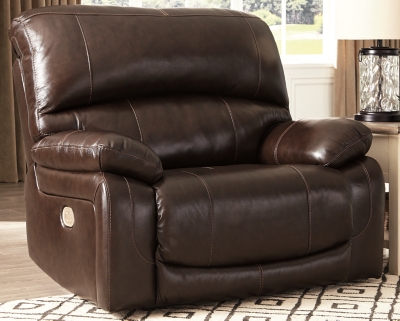 Fashion-forward style. Sumptuous leather feel and appeal. Total comfort at your fingertips. It’s all yours for the taking with the Hallstrung power recliner with adjustable headrest. Wrapped in a lavish chocolate-colored upholstery, this decidedly contemporary power recliner tantalizes the senses in so many ways. Rest assured, the wide seating area is covered in 100% leather for your pleasure, while a skillfully matched faux leather on the exterior makes luxury affordable. Upping the comfort with 44" high back styling, this power recliner truly caters from head to toe. An Easy View™ power adjustable headrest allows you to lean back while propping up your head—perfect for chilling out in front of the TV—while an extended ottoman lets you stretch out all the more. And with a USB port in the power control panel, you hardly have to move a muscle to stay powered up.High-resiliency foam cushions wrapped in thick poly fiber | Corner-blocked frame with metal reinforced seat | One-touch power control with adjustable positions | 44" high back design | Attached back and seat cushions | Easy View™ power adjustable headrest | Extended ottoman for enhanced comfort | Leather interior upholstery; polyester/vinyl exterior upholstery | Includes USB charging port in each power control | Power cord included; UL Listed | Estimated Assembly Time: 15 Minutes