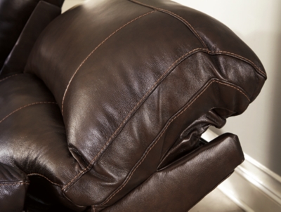 Fashion-forward style. Sumptuous leather feel and appeal. Total comfort at your fingertips. It’s all yours for the taking with the Hallstrung power recliner with adjustable headrest. Wrapped in a lavish chocolate-colored upholstery, this decidedly contemporary power recliner tantalizes the senses in so many ways. Rest assured, the wide seating area is covered in 100% leather for your pleasure, while a skillfully matched faux leather on the exterior makes luxury affordable. Upping the comfort with 44" high back styling, this power recliner truly caters from head to toe. An Easy View™ power adjustable headrest allows you to lean back while propping up your head—perfect for chilling out in front of the TV—while an extended ottoman lets you stretch out all the more. And with a USB port in the power control panel, you hardly have to move a muscle to stay powered up.High-resiliency foam cushions wrapped in thick poly fiber | Corner-blocked frame with metal reinforced seat | One-touch power control with adjustable positions | 44" high back design | Attached back and seat cushions | Easy View™ power adjustable headrest | Extended ottoman for enhanced comfort | Leather interior upholstery; polyester/vinyl exterior upholstery | Includes USB charging port in each power control | Power cord included; UL Listed | Estimated Assembly Time: 15 Minutes